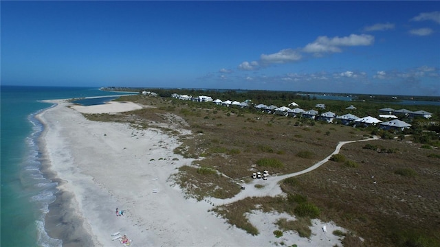 birds eye view of property featuring a water view and a beach view