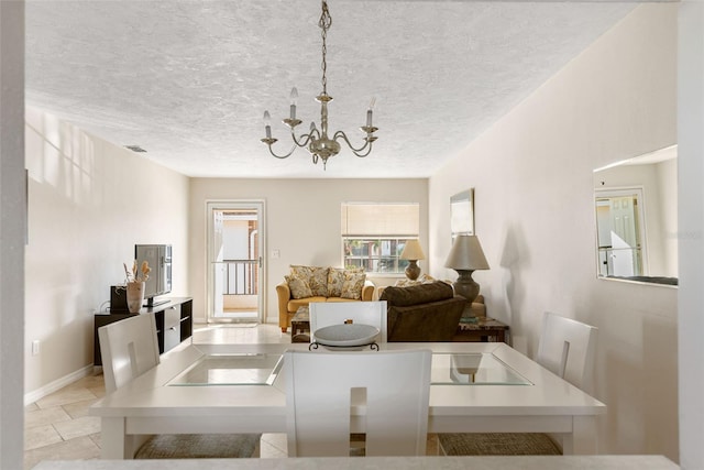 dining area with a chandelier and a textured ceiling