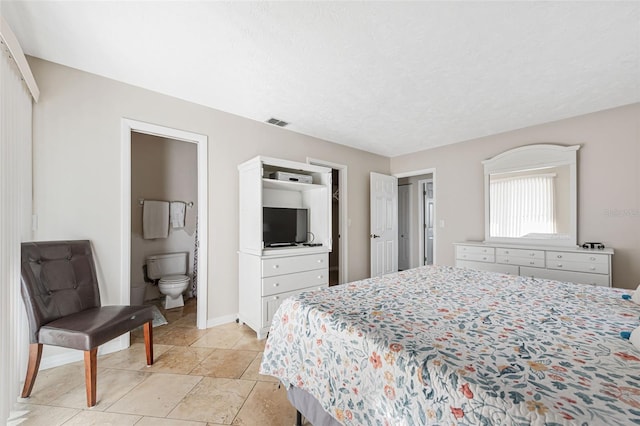 bedroom featuring connected bathroom and a textured ceiling