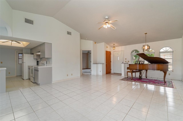 tiled living room with lofted ceiling and ceiling fan with notable chandelier