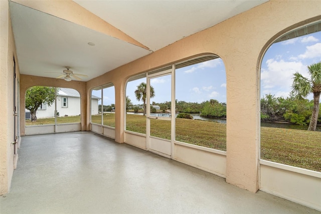 unfurnished sunroom with ceiling fan and vaulted ceiling