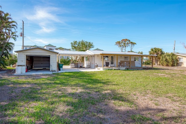 ranch-style house with covered porch, a garage, a front lawn, and an outdoor structure