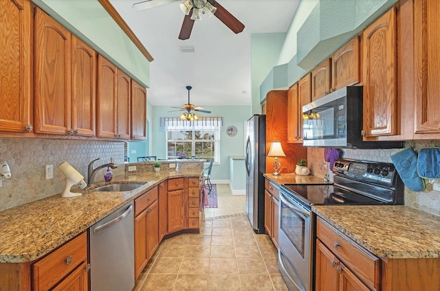 kitchen with light stone countertops, appliances with stainless steel finishes, backsplash, and sink