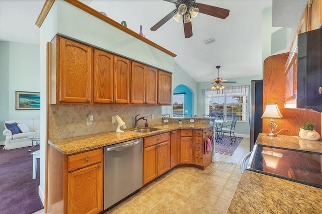 kitchen featuring lofted ceiling, backsplash, light stone countertops, appliances with stainless steel finishes, and kitchen peninsula