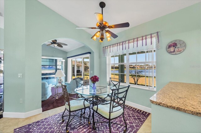 tiled dining space with vaulted ceiling and ceiling fan