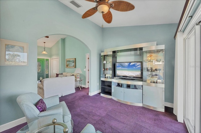 carpeted living room with ceiling fan and vaulted ceiling