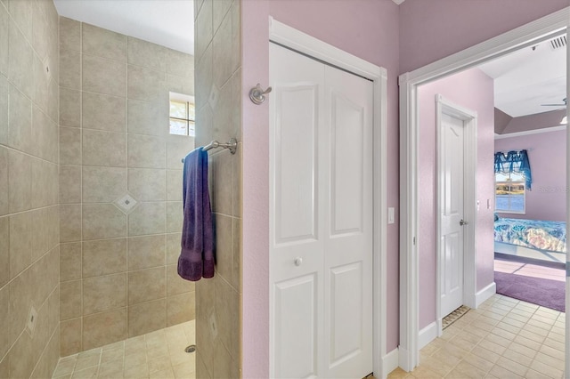 bathroom with tile patterned floors, ceiling fan, and tiled shower