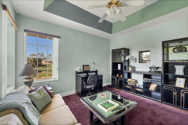 carpeted living room featuring ceiling fan and a raised ceiling