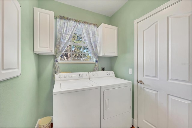 clothes washing area featuring cabinets and washing machine and dryer