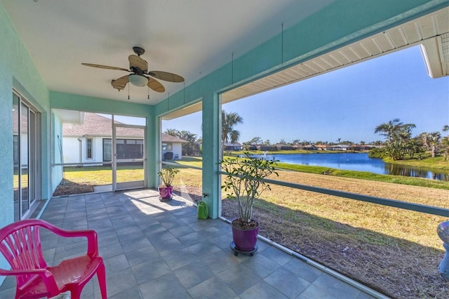 sunroom featuring a water view and ceiling fan