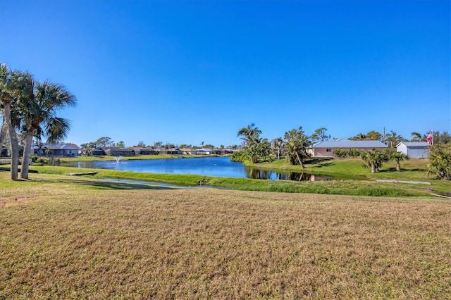 view of property's community with a lawn and a water view