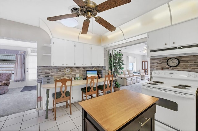 kitchen with white electric stove, white cabinetry, light tile patterned floors, and backsplash