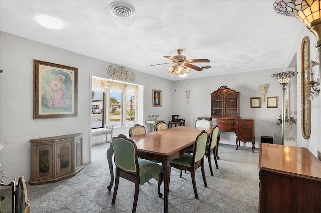 dining area featuring light colored carpet and ceiling fan