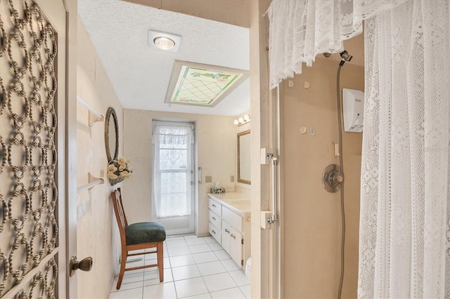 bathroom featuring tile patterned floors, vanity, and a textured ceiling