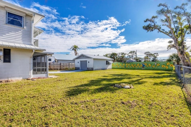 view of yard featuring a garage and a sunroom