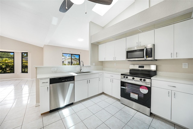 kitchen featuring white cabinets, sink, lofted ceiling with skylight, and stainless steel appliances