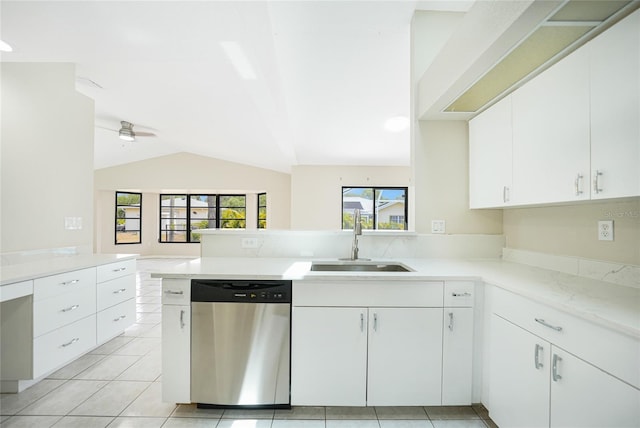 kitchen with kitchen peninsula, stainless steel dishwasher, sink, white cabinets, and lofted ceiling