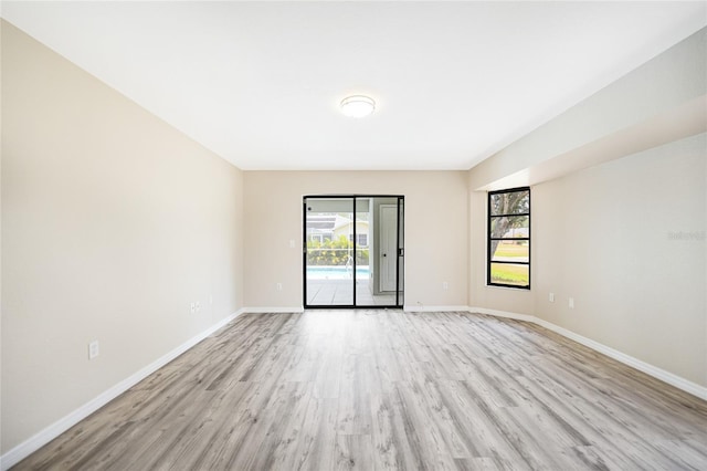 spare room with plenty of natural light and light hardwood / wood-style flooring