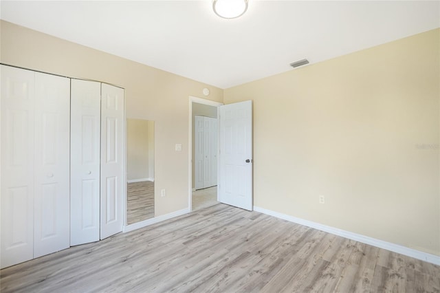 unfurnished bedroom with a closet and light hardwood / wood-style floors