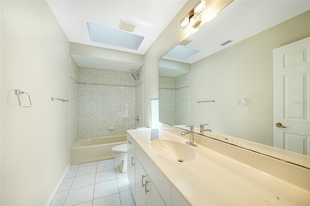 full bathroom featuring a skylight, vanity, tile patterned flooring, toilet, and tiled shower / bath