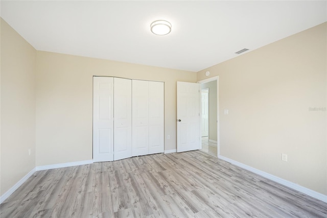 unfurnished bedroom featuring light hardwood / wood-style flooring and a closet