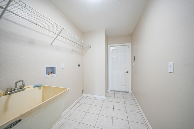 laundry room with sink, electric dryer hookup, hookup for a washing machine, a textured ceiling, and light tile patterned flooring