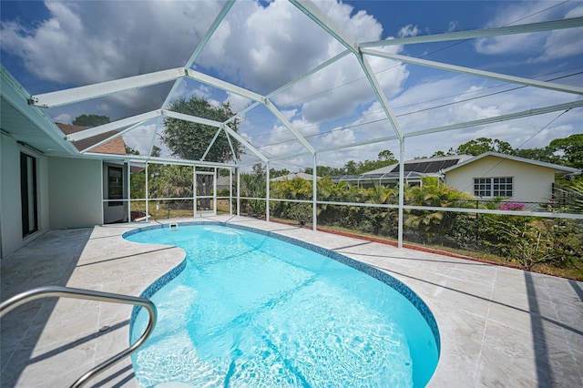 view of swimming pool featuring a lanai and a patio area