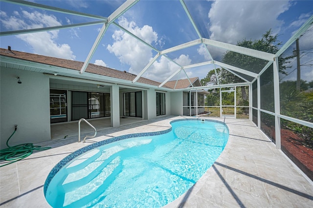 view of swimming pool featuring a lanai and a patio