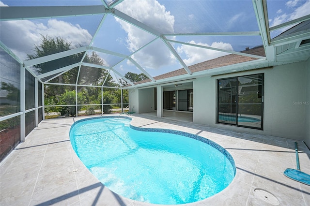 view of swimming pool featuring a lanai, ceiling fan, and a patio area