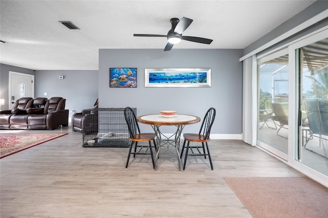 dining area featuring ceiling fan, light hardwood / wood-style flooring, and a textured ceiling