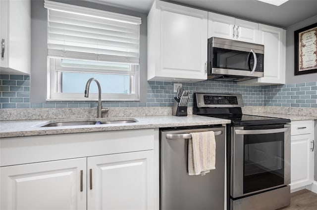 kitchen featuring backsplash, sink, white cabinetry, and stainless steel appliances