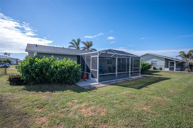 back of house with a yard and a lanai