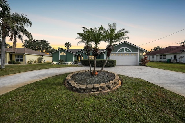 ranch-style house featuring a yard and a garage