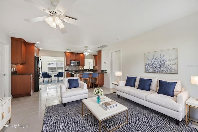 tiled living room with ceiling fan