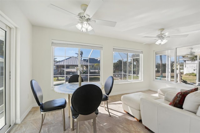 sunroom / solarium featuring ceiling fan