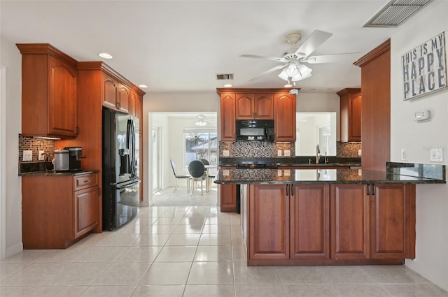 kitchen with black appliances, ceiling fan, dark stone countertops, light tile patterned flooring, and kitchen peninsula