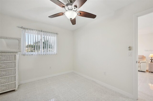 spare room with ceiling fan and light tile patterned flooring