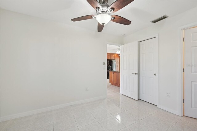 unfurnished bedroom featuring ceiling fan, a closet, and light tile patterned flooring