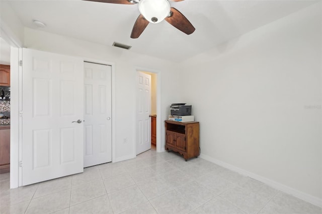 tiled bedroom featuring ceiling fan and a closet