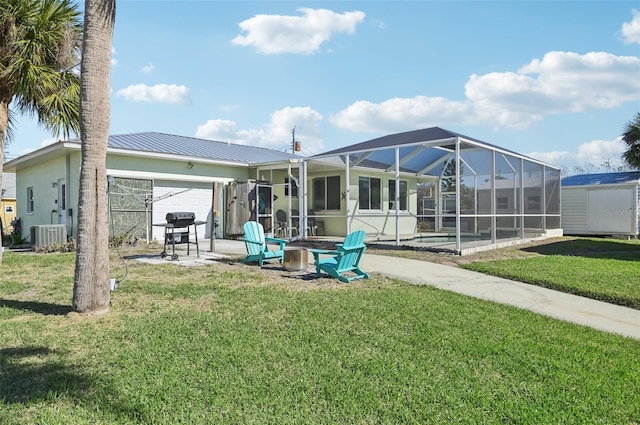 rear view of house featuring a lanai, a yard, and a patio