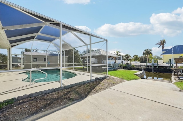 view of pool with a lanai, a patio, and a water view