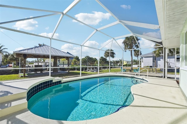 view of swimming pool with a gazebo, a patio, and glass enclosure