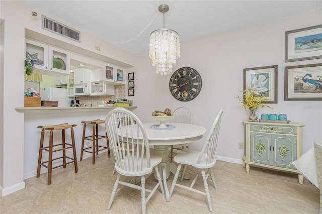 dining space with light tile patterned flooring and an inviting chandelier