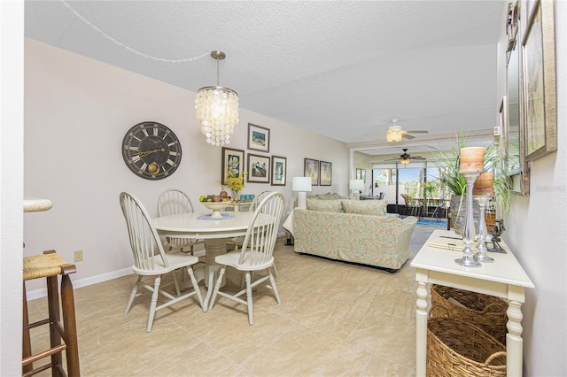 dining area featuring a textured ceiling and ceiling fan with notable chandelier