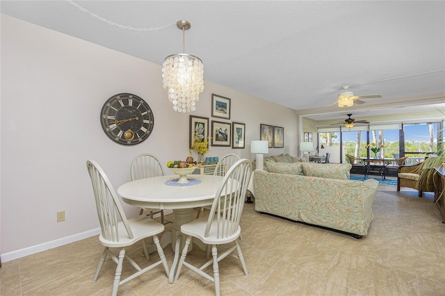 dining space featuring a textured ceiling and ceiling fan with notable chandelier