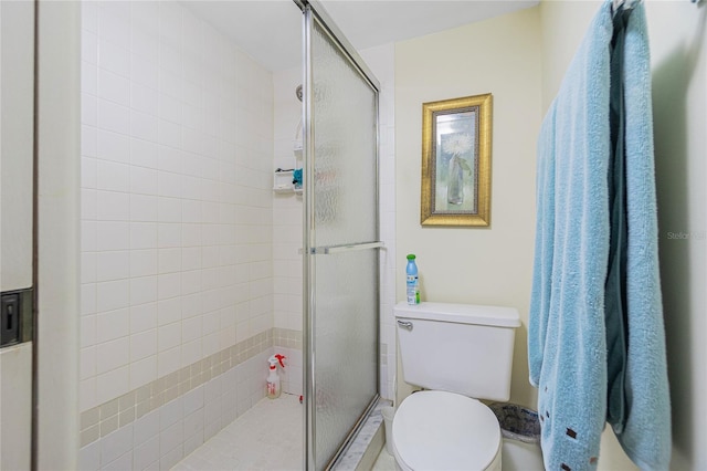 bathroom with toilet and a shower with shower door