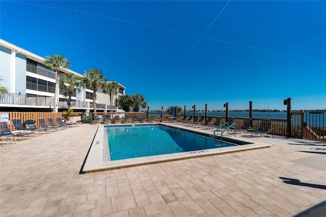 view of pool with a water view and a patio