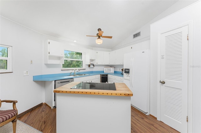 kitchen with a wealth of natural light, vaulted ceiling, black appliances, light hardwood / wood-style flooring, and white cabinets