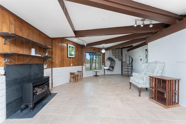 unfurnished room with a wood stove, wooden walls, and light tile patterned floors