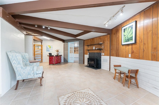 living room with vaulted ceiling with beams, a wood stove, and wood walls